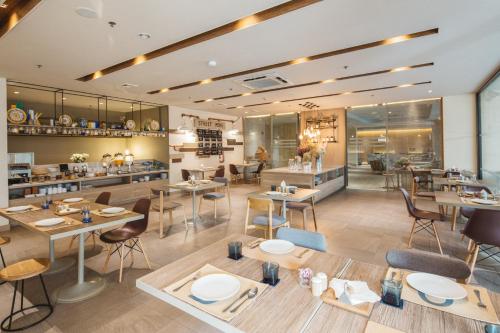 a restaurant with tables and chairs and a cafeteria at Clef Hotel Bangkok in Bangna