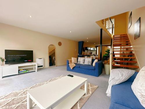 a living room with a blue couch and a tv at City Center Stay With Parking in Hobart