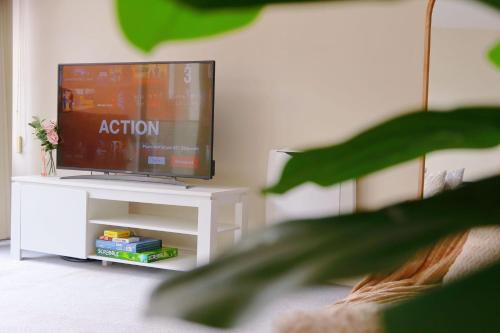 a flat screen tv on a white stand in a living room at City Center Stay With Parking in Hobart