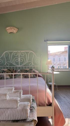 a bedroom with a bed with a green headboard and a window at Stella in Terlizzi