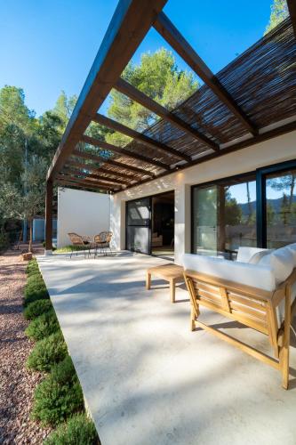 a patio with two beds under a wooden roof at Alojamiento Rural 1Respiro Parque Natural Serra Calderona in Serra
