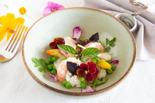 a bowl of food with rice and flowers on a table at lO GORISSADO - La ferme du glandier in Saint-André-dʼAllas