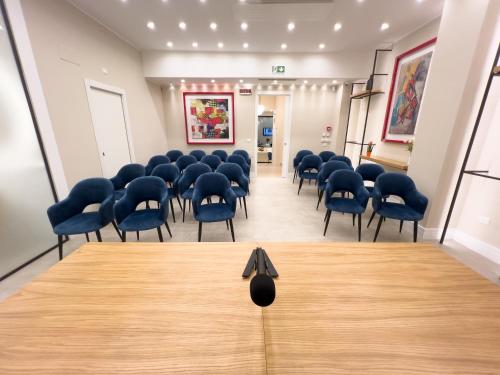 a room with chairs and a table with a black bow at Palazzo Bibbi - Rooms to Live in Reggio Calabria