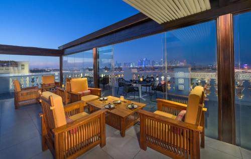a balcony with tables and chairs and a view of the city at Souq Waqif Boutique Hotels - Tivoli in Doha