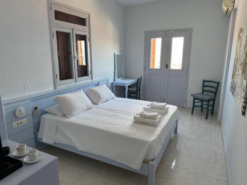 a bedroom with a bed with towels on it at Hotel Fiona Symi in Symi