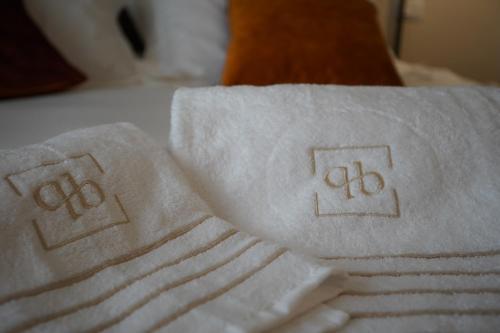 a pile of towels sitting on top of a bed at Palazzo Bibbi - Rooms to Live in Reggio Calabria