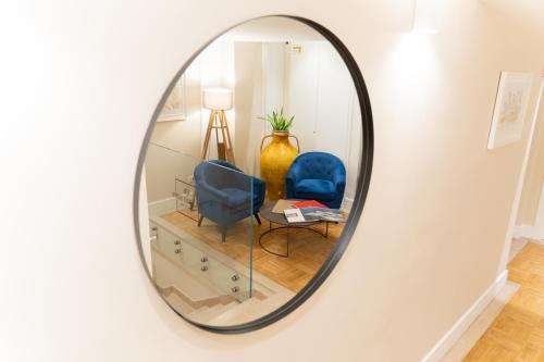 a mirror in a room with a blue chair at Palazzo Bibbi - Rooms to Live in Reggio Calabria
