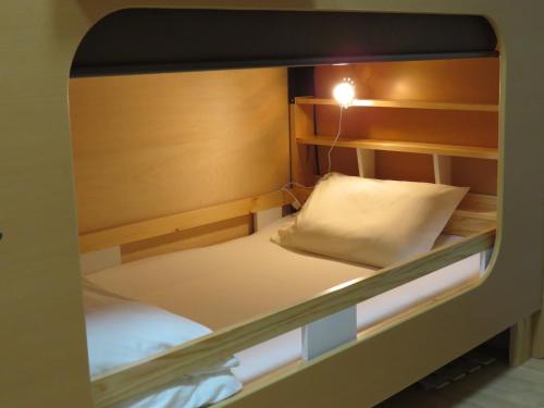 een kleine slaapkamer met een stapelbed en een kussen bij Guesthouse Channel-Kan in Kamojima