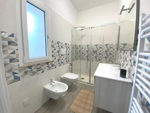 a bathroom with a toilet and a sink and a shower at L'Angolo di Portorose in Fregene