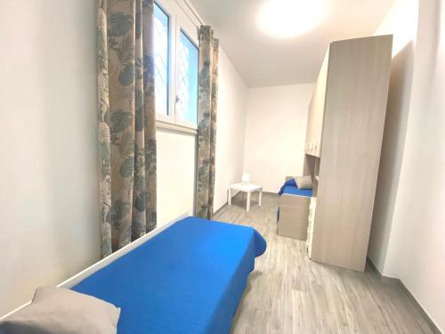 a small room with a blue bed and a window at L'Angolo di Portorose in Fregene