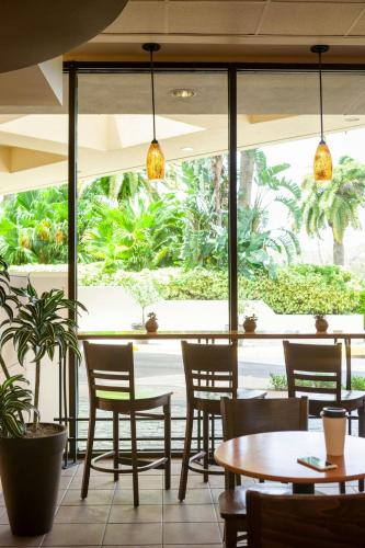 a restaurant with tables and chairs and a large window at Marriott Orlando Airport Lakeside in Orlando