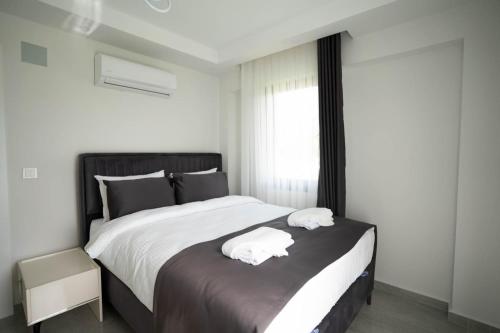 Un dormitorio con una cama grande con dos toallas encima. en MSD Konakları, en Muğla