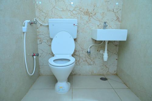a bathroom with a toilet and a sink at Vaarahi Guest Inn in Nellore