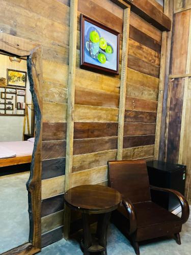 a room with a wooden wall with a table and a chair at Ôna's House - Homestay Pleiku in Pleiku