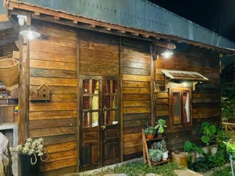 a wooden house with a book shelf in front of it at Ôna's House - Homestay Pleiku in Pleiku