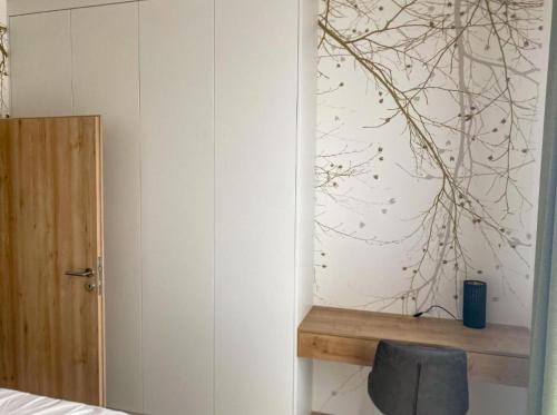 a bedroom with a wall with a tree mural at PanorámaX12 Hillside apartmán in Dolný Kubín