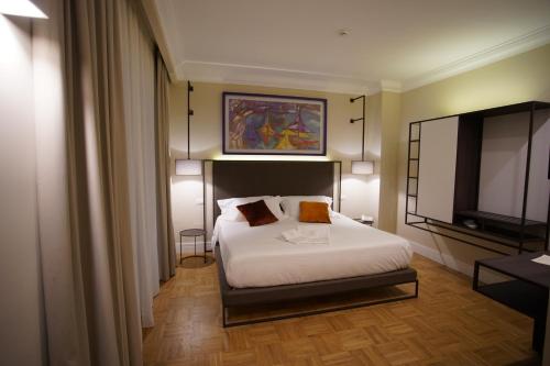 a hotel room with a bed and a television at Palazzo Bibbi - Rooms to Live in Reggio Calabria