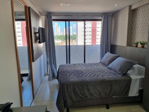 una camera da letto con un letto e una finestra con vista di Espetacular Apart Hotel Manaíra a João Pessoa