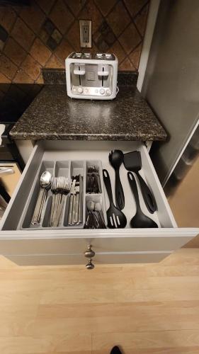 a drawer filled with cooking utensils on a kitchen counter at Happy Life in Barrie