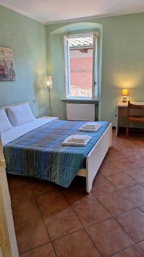 ein Schlafzimmer mit einem großen Bett mit Fenster in der Unterkunft Apartments Cabianchi in Orta San Giulio