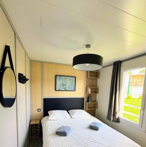 une chambre avec un lit avec deux serviettes dessus dans l'établissement Chalet Finistère-Sud avec piscine chauffée, à Pont-lʼAbbé