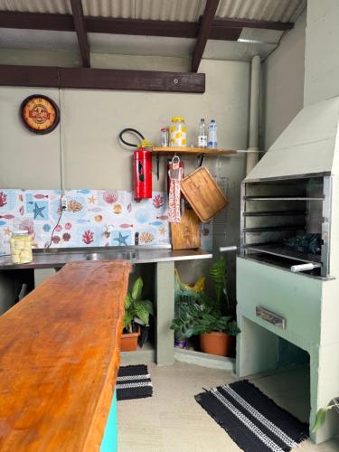 a kitchen with a counter with a table and a grill at Suite 3- Praia bonita Hospedagem,agora com ar condicionado in São Francisco do Sul