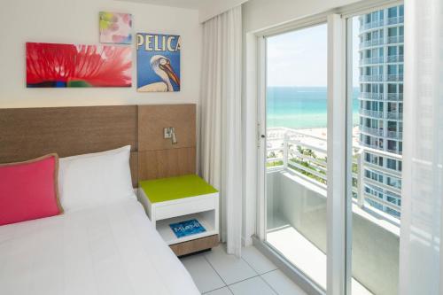 a bedroom with a bed and a balcony with the ocean at Royal Palm South Beach Miami, a Tribute Portfolio Resort in Miami Beach