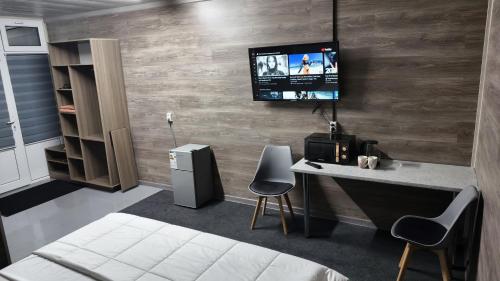 a room with a desk and a tv on a wall at The Mini-hotel on Mukanov St in Almaty