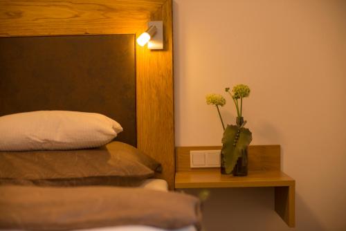a bedroom with a bed and a vase with flowers in it at Kendlhof in Sankt Johann im Pongau