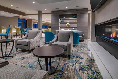 a lobby with chairs and tables and a fireplace at TownePlace Suites By Marriott Wrentham Plainville in Wrentham