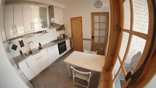 une cuisine avec des armoires blanches et un comptoir dans l'établissement Appartement Coup de coeur, à Lille