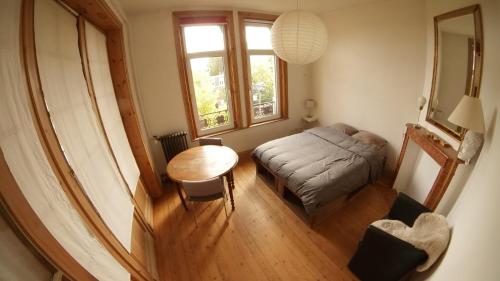 - un petit salon avec une table et un lit dans l'établissement Appartement Coup de coeur, à Lille