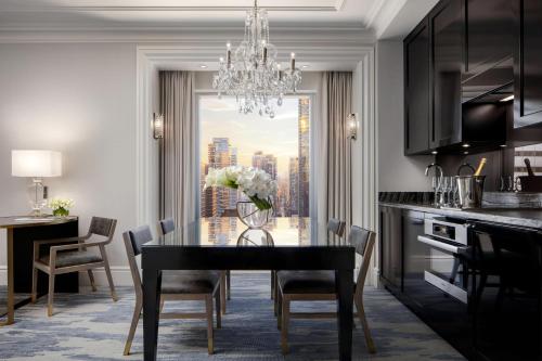 a dining room with a black table and a chandelier at The St. Regis Toronto in Toronto