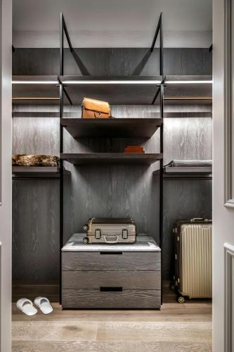 a walk in closet with a suitcase and shelves at The St. Regis Toronto in Toronto