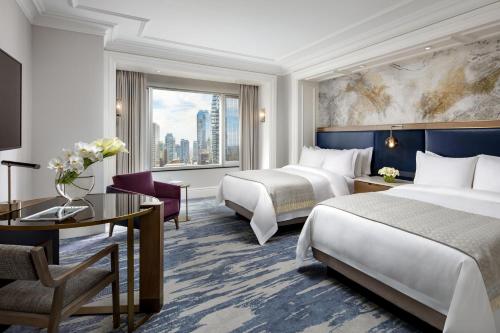 a hotel room with two beds and a desk at The St. Regis Toronto in Toronto