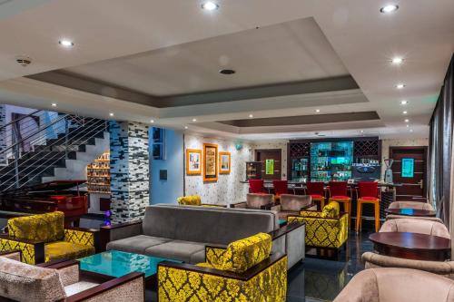 a lobby with chairs and tables and a bar at Protea Hotel by Marriott Lagos Kuramo Waters in Lagos