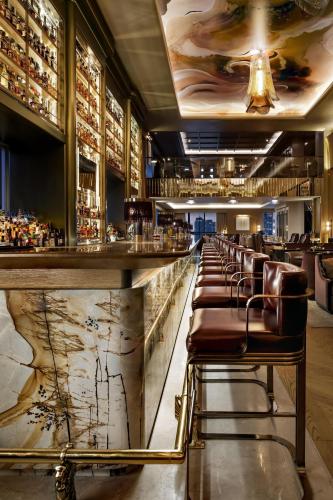 a bar with a row of leather chairs at a bar at The St. Regis Toronto in Toronto