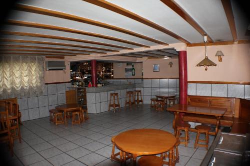 a restaurant with wooden tables and chairs and a kitchen at Hotel Las Nieves in Las Nieves