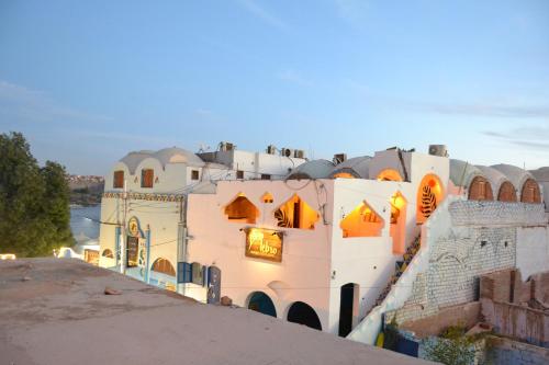 a large white building with orange lights on it at Nebro Nubian Guest House - Adults Only in Aswan