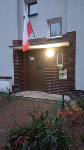 a house with a flag on the front of it at PRADA Apartament Konin in Konin