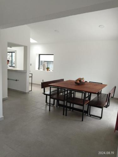 a dining room with a wooden table and chairs at Casa vacacional in Oaxtepec