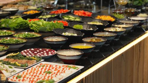 a buffet with many bowls of food on a table at Góralski Resort Pool & SPA in Białka Tatrzanska