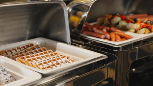 a buffet with two trays of waffles and other food at Góralski Resort Pool & SPA in Białka Tatrzanska