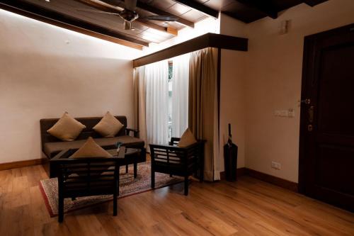a living room with a couch and a table at Aahana Resort - Jim Corbett in Rāmnagar