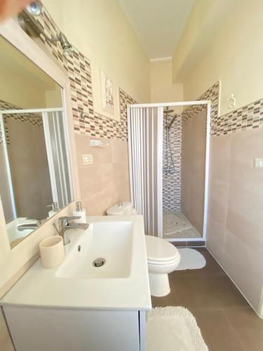 a white bathroom with a sink and a toilet at B&B Affittacamere La Dolce Mela in Francavilla di Sicilia