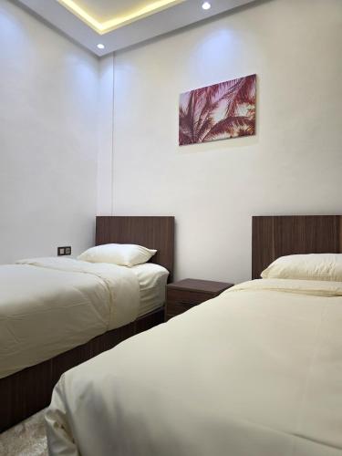 アガディールにあるScenic Tamraght Cozy Studioのベッド2台が備わる部屋、壁に絵が飾られた部屋