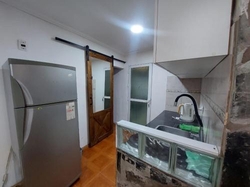 a small kitchen with a sink and a refrigerator at El descanso in Necochea