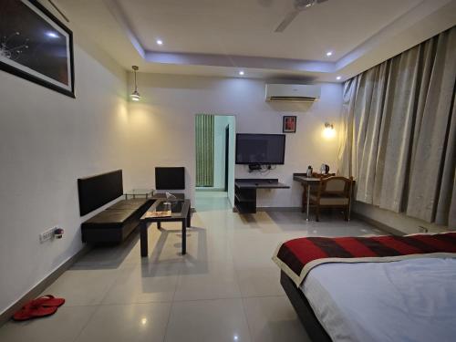 a hotel room with a bed and a living room at Hotel Vikramaditya in Gangānagar
