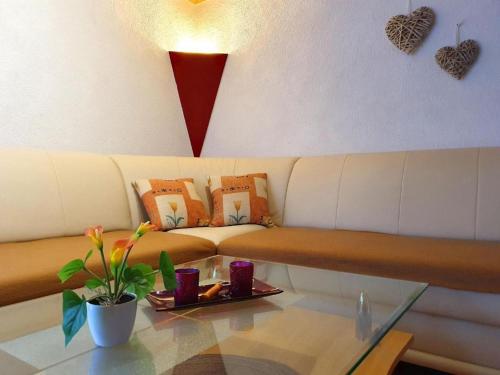 Una sala de estar con un sofá y una mesa de cristal. en FewoJunkernberg, en Hasselfelde
