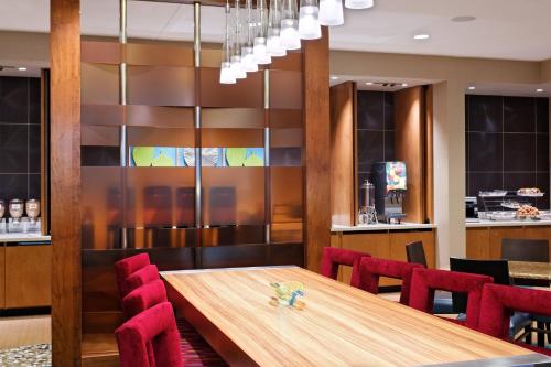 a dining room with a wooden table and red chairs at SpringHill Suites by Marriott Pensacola in Pensacola